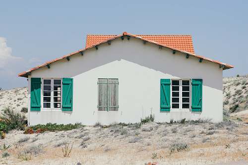 france white and green concrete house with windows open at daytime house