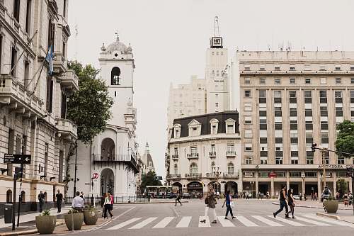 architecture woman crossing pedestrian lane between tall buildings urban
