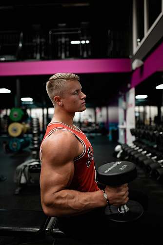 fitness man standing while holding dumbbell inside gym sport