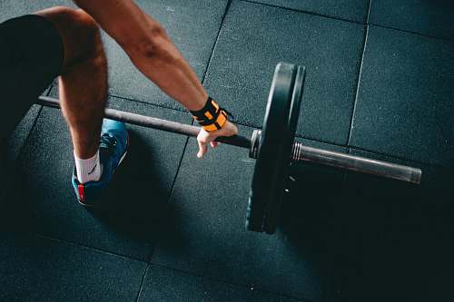 person man holding black barbell human
