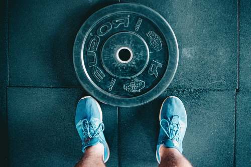 gym person standing beside black weights shoe