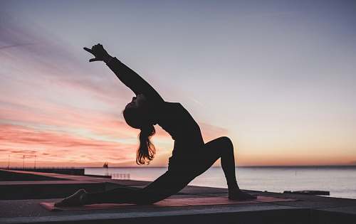 sport silhouette photography of woman doing yoga yoga