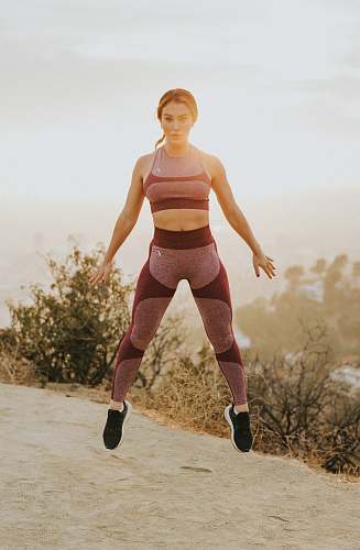 human woman jumping above gray sand people