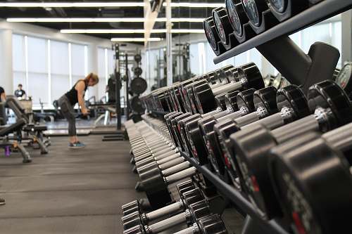 gym woman standing surrounded by exercise equipment exercise