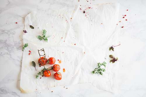 herbs closeup photo of fruits on white surface tomato