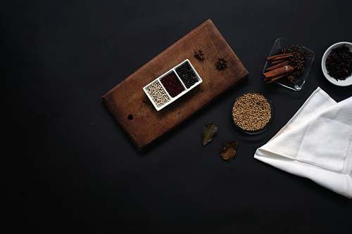 flaylay flat lay photography of beans on brown wooden board beside white handkerchief dark background