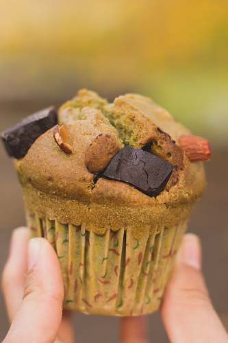 muffin person holding brown cupcake dessert