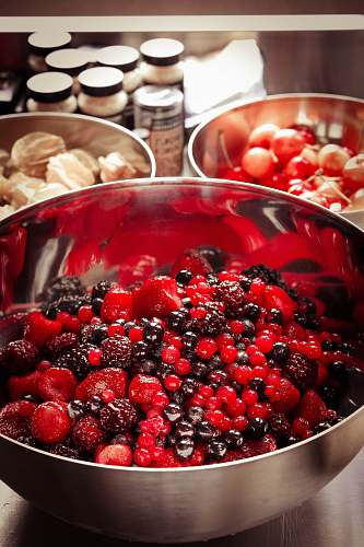plant red and black fruit on gray stainless steel bowl fruit