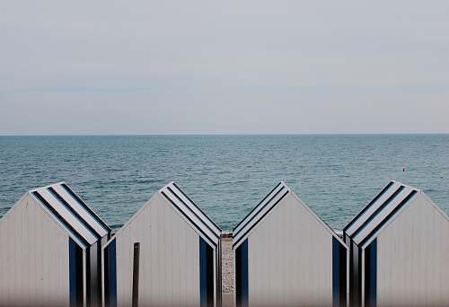 hut four white-and-blue sheds on shoreline grey