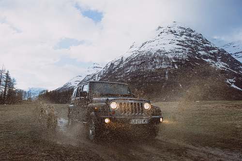 car photo of gray Jeep Cherokee near snow-covered mountain vehicle