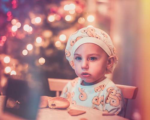 person baby sitting next to a table with bread people