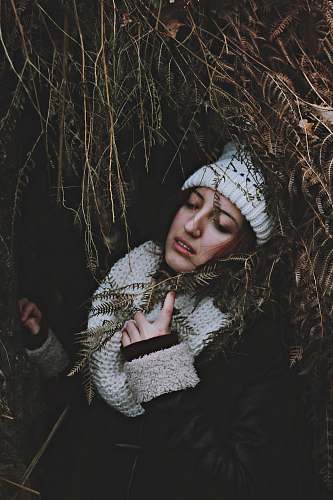person woman under arc of dried leaves holding scarf people