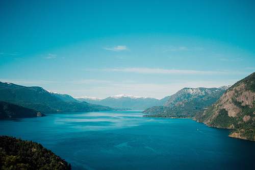 outdoors calm body of water surround with mountain during daytime land