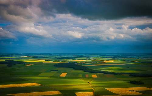 sky aerial photo of green and brown field cloud