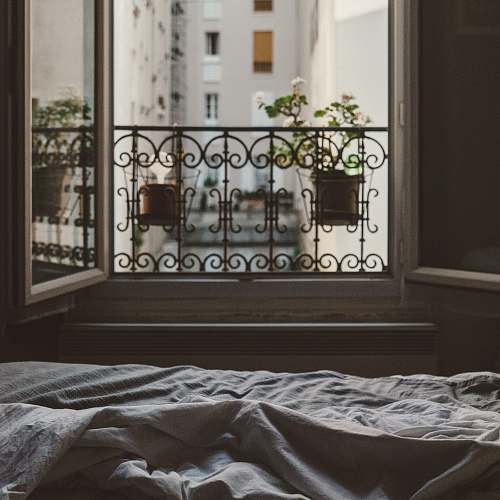 bed closeup photo of open window with flower window