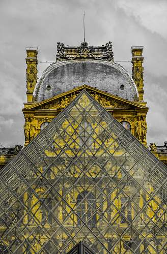 architecture photo of glass triangle-shape building under nimbus cloud structure