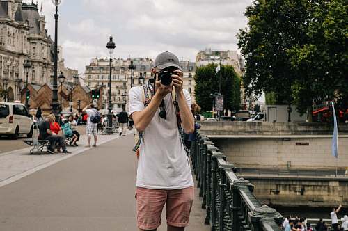 human man holding DSLR camera beside bridge person