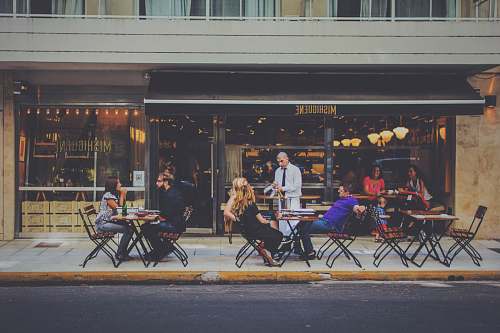 person people sitting on chairs in front of facade restaurant