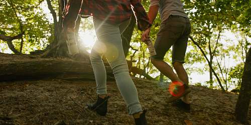 human A man and woman walking in a forest holding a Boxed Water carton flare