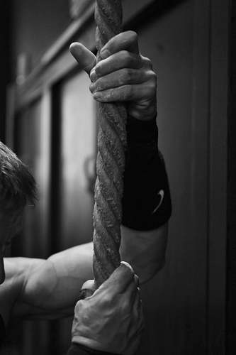 human gray scale photo of man holding rope black-and-white
