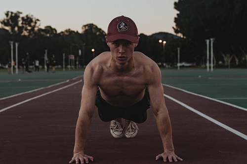 human man doing push-ups on a track field fitness