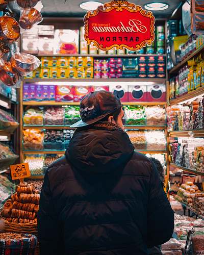 human man in black hooded bubble jacket in store market