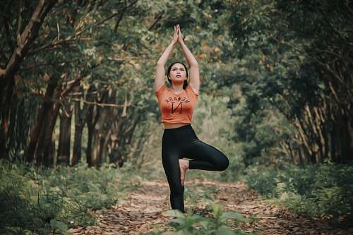 human woman doing yoga near trees yoga