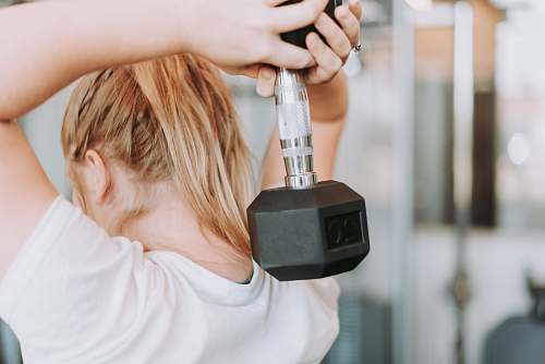 human woman holding dumbbell in white crew-neck t-shirt people