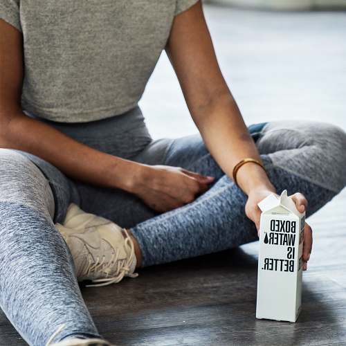 human woman sitting on floor holding carton box apparel