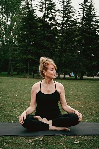 human woman squatting on a yoga mat working out