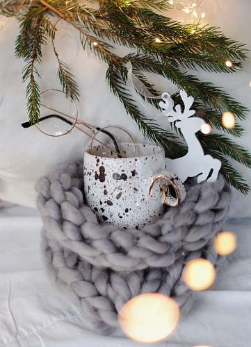tree white reindeer decor near white and brown ceramic mug, eyeglasses, and green pine tree egg