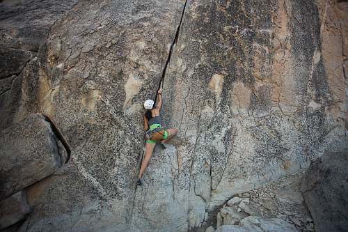 climbing woman climbing on rock cliff during daytime outdoors