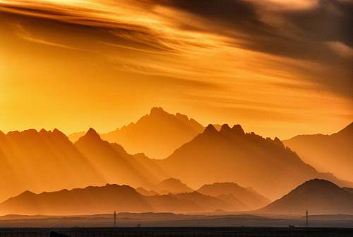 sunrise landscape photography of brown mountains orange