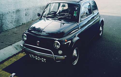 car black 3-door hatchback parked near gray concrete wall outdoor vehicle
