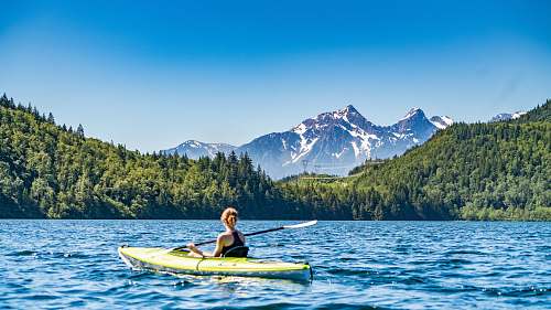 lake woman kayaking on lake during daytime mountain