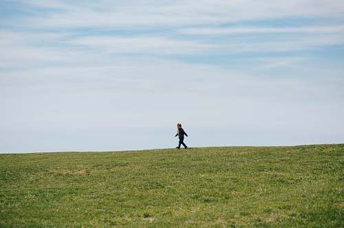 grassland child walking on green grass field grass