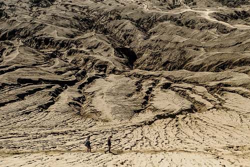 sand brown mountain range with two people soil