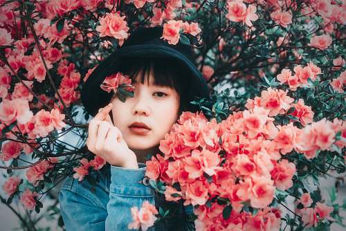 human woman standing surrounded by pink flowers people