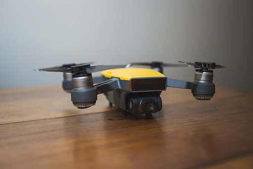 hardwood yellow and black DJI drone on wooden surface quadcopter