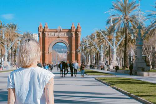 person woman standing on road near concrete arch at daytime arch