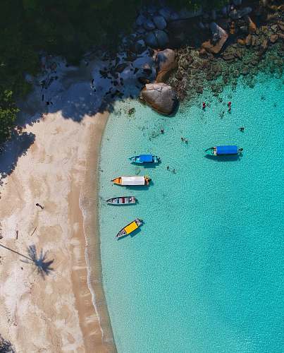 outdoors aerial view photography of boats on seashore sand