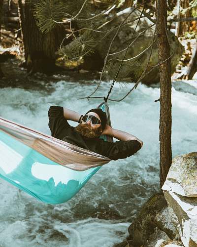 transportation man reclining on blue and brown hammock vessel