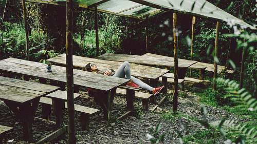 plant woman lying on gray wooden picnic table sleep