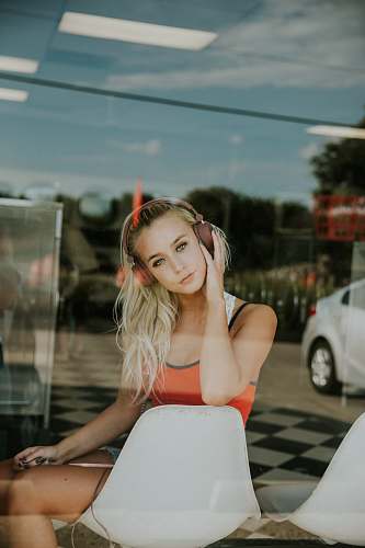 people woman sits on chair behind glass wall woman