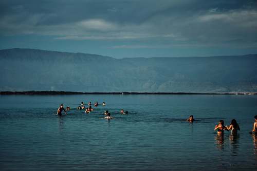 people group of people in body of water near green mountain israel