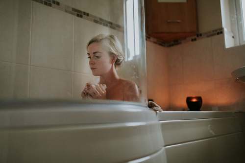 people naked woman sitting inside bath tub person