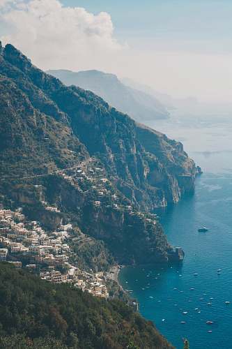 outdoors buildings and houses on top of mountains surrounded by body of water cliff