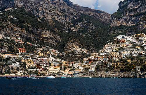 city concrete buildings on mountain near body of water at daytime town