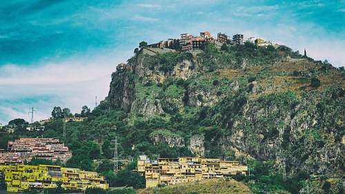 castelmola landscape photography of concrete structures on top of mountain village