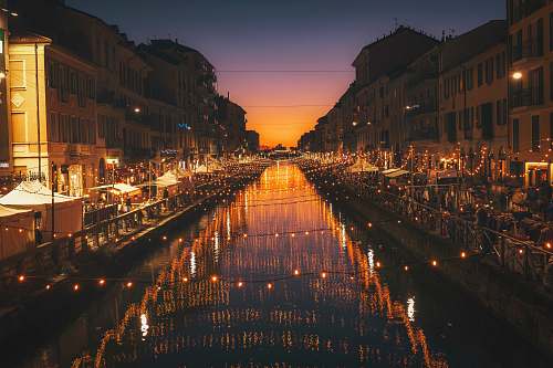 milano reflective photography of string lights above river urban